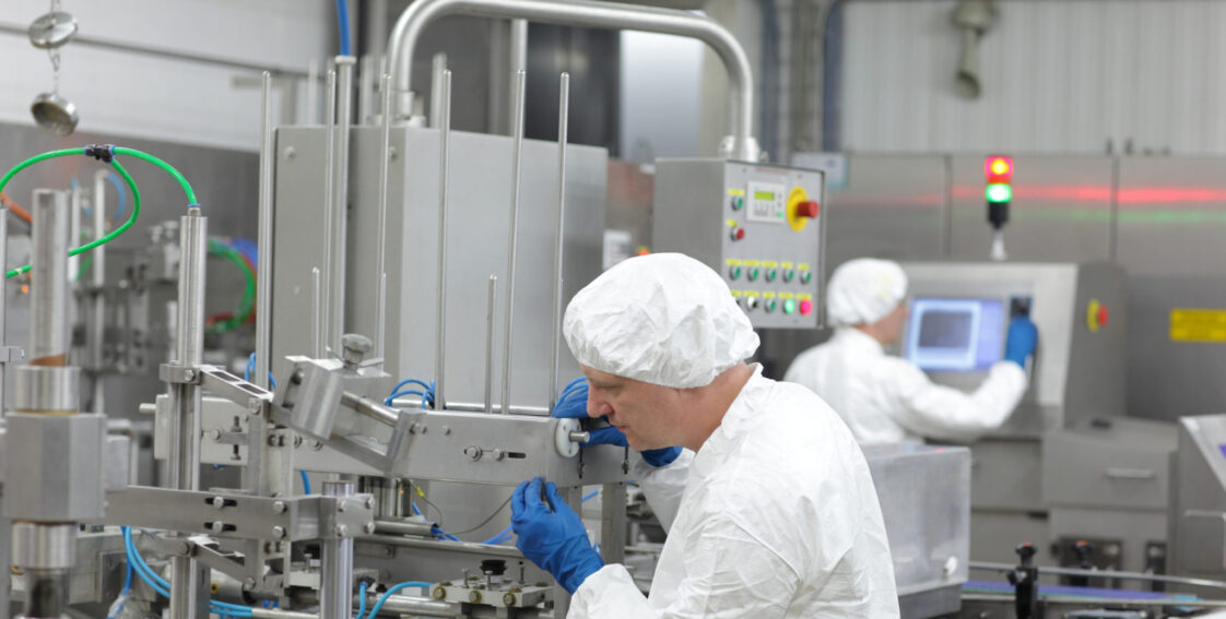 two workers at production line in plant