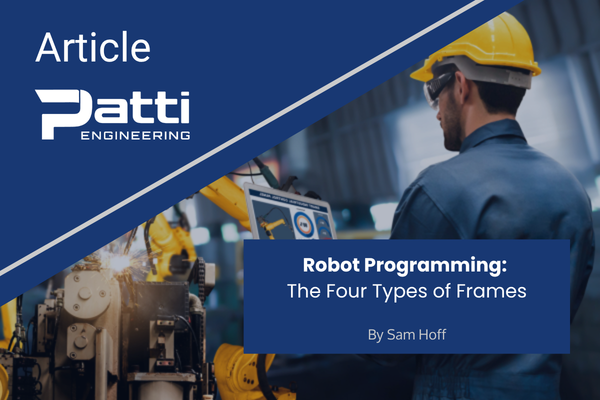 Engineer using laptop to control robotic arm in industrial setting.