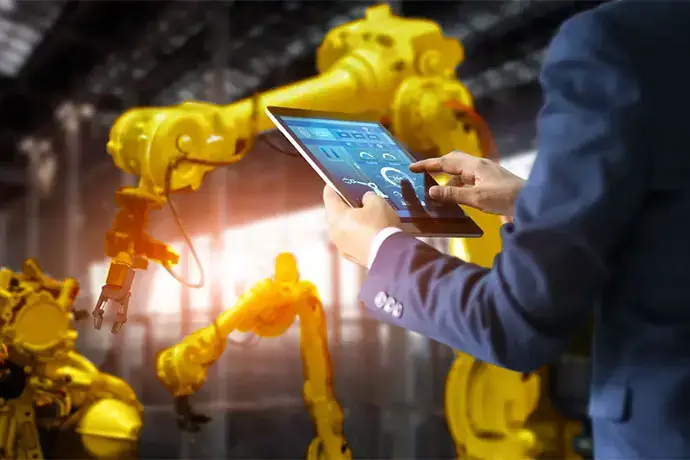 Industrial manager, engineer using tablet checking and controlling automation robot arms machine in intelligent factory industrial on monitoring system software.