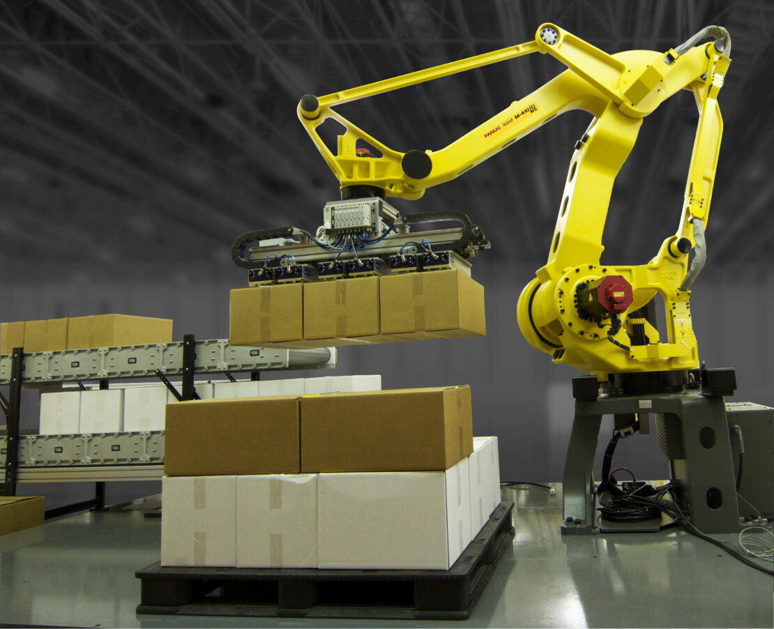 Palletizing robot handling cases at end of production line in food manufacturing facility